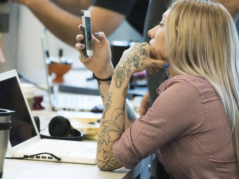 Frau am Schreibtisch mit Handy