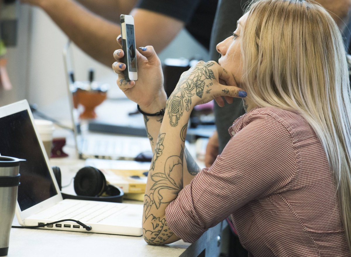 Frau am Schreibtisch mit Handy