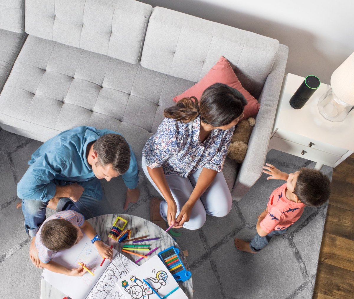 Eine Familie vor einem Echo-Lautsprecher von Amazon.