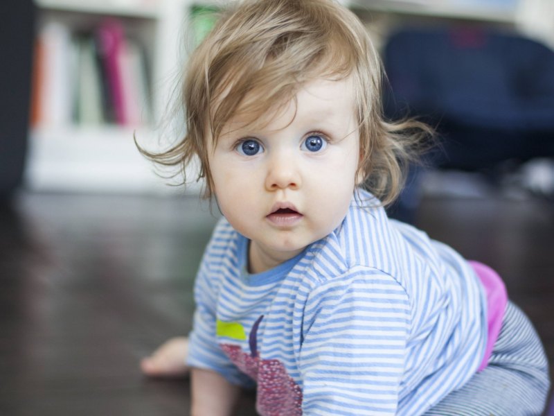 Ein Baby schaut erschrocken in die Kamera.