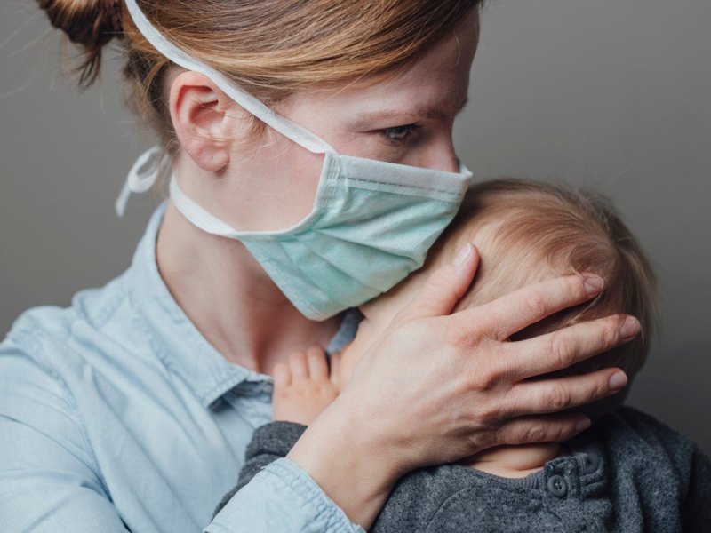 Maskierte Mutter mit ihrem Baby