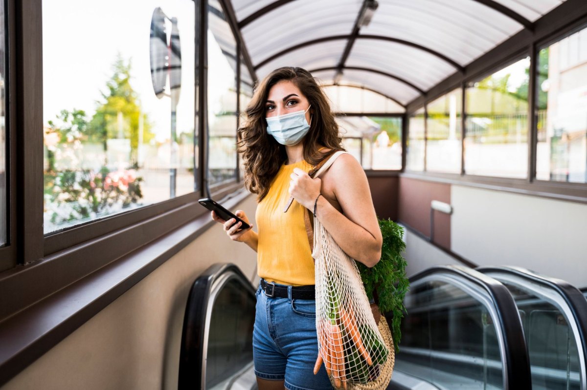 Frau mit Maske und Lebensmittel