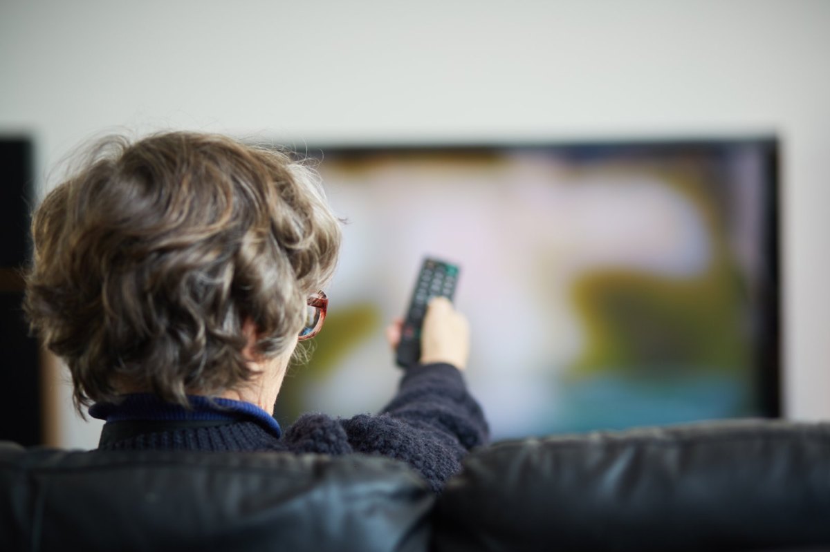 Mann sitzt vor einem Fernseher