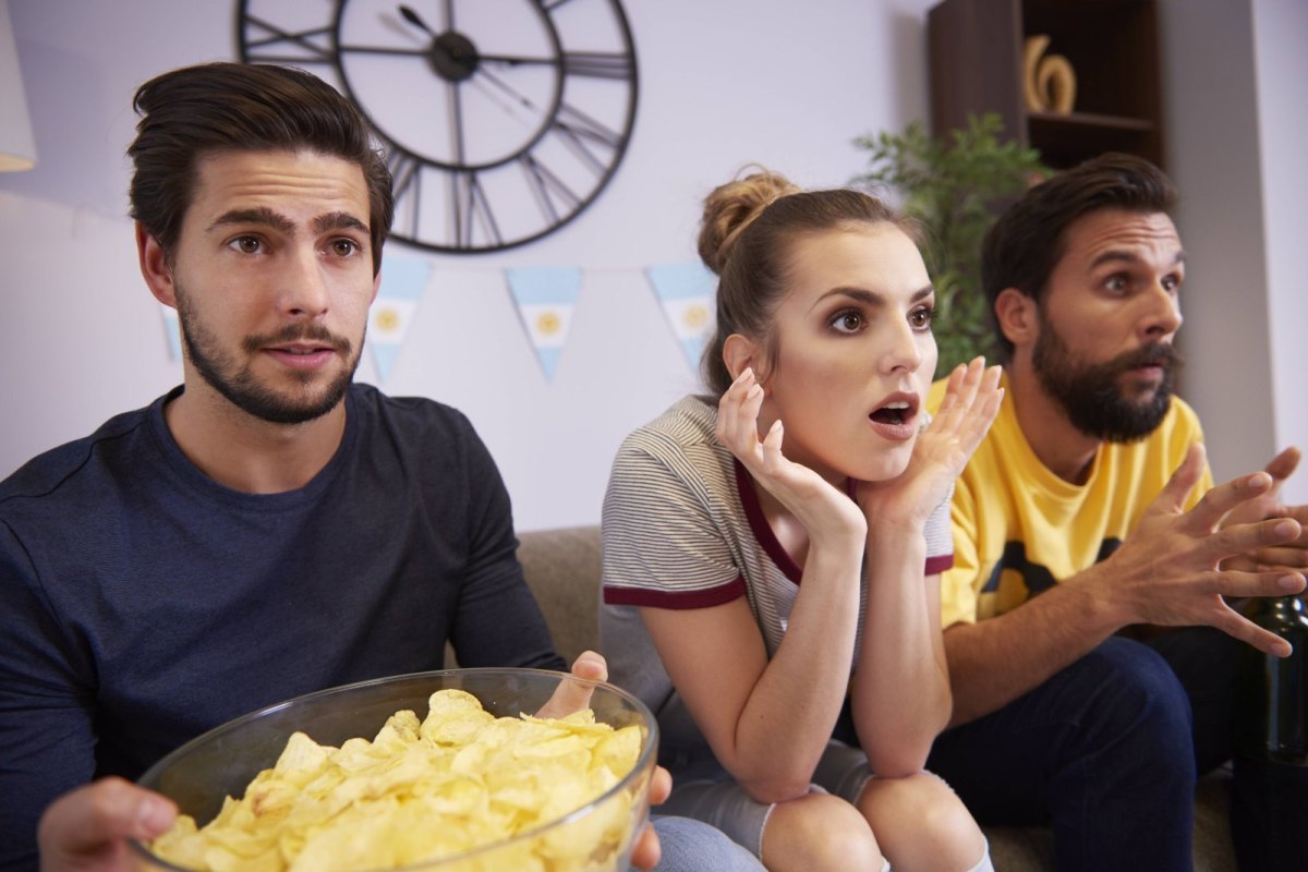 Überraschte Menschen vor dem Fernseher