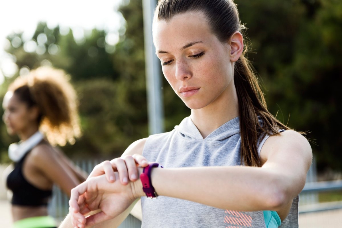 Frau mit Fitness-Tracke am Arm.