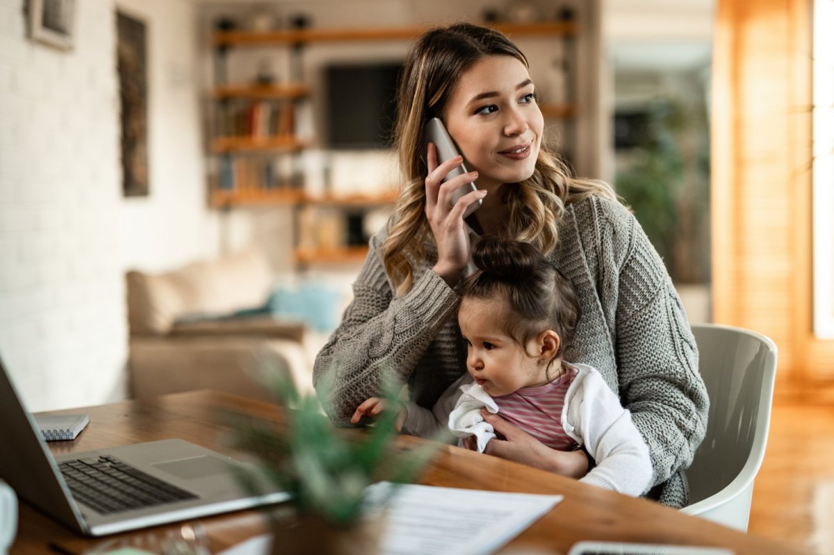 Frau mit Kind und schnurlosem Telefon.