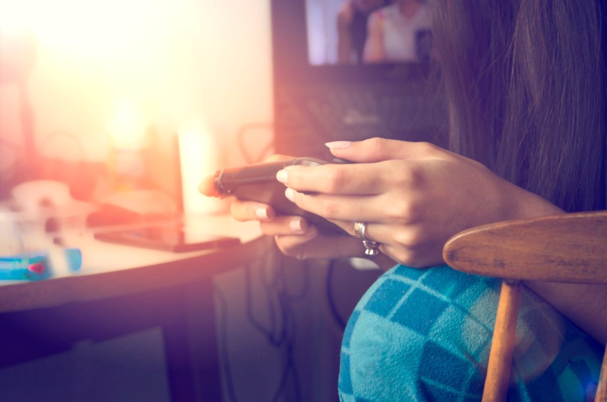 Frau spielt mit Handheld-Konsole.