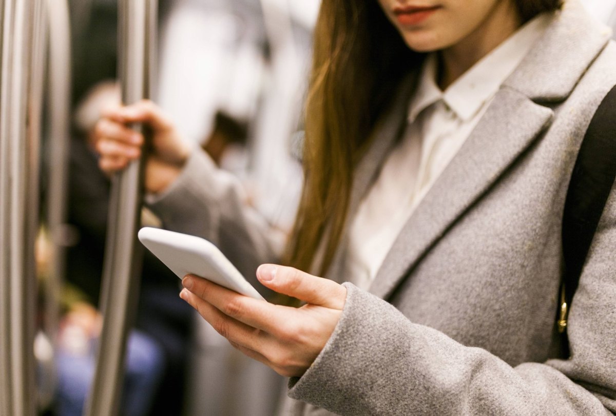 Frau mit einem Handy in der U-Bahn