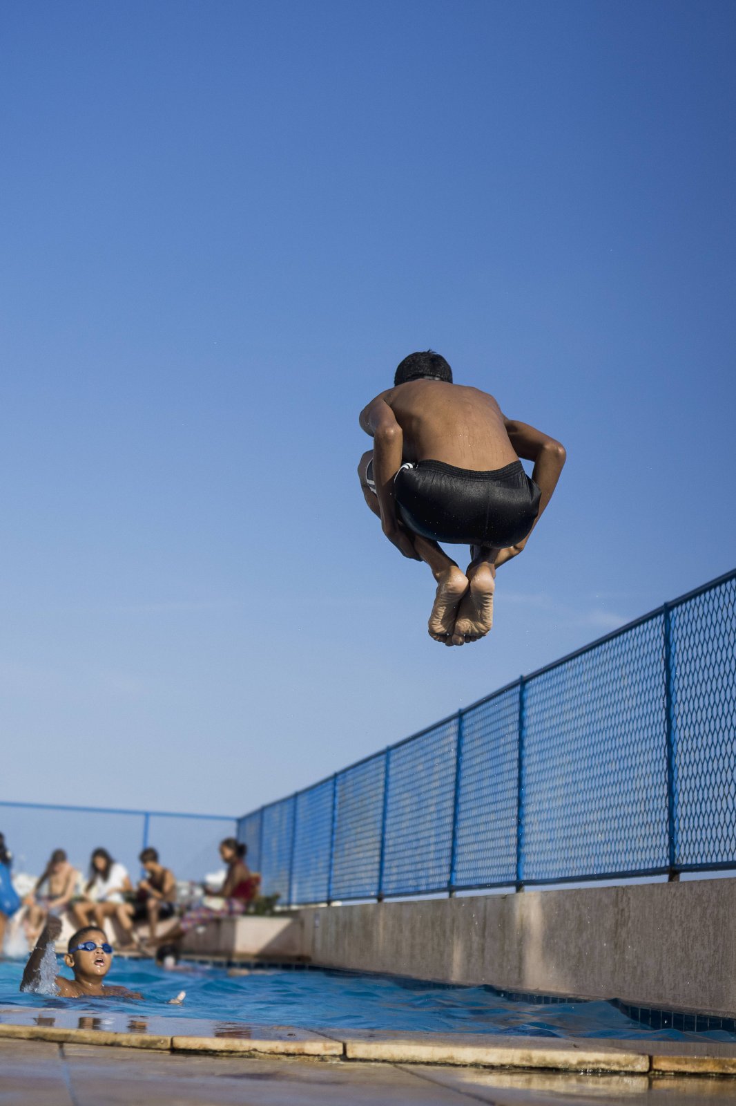 Ein Junge springt in den Swimming Pool