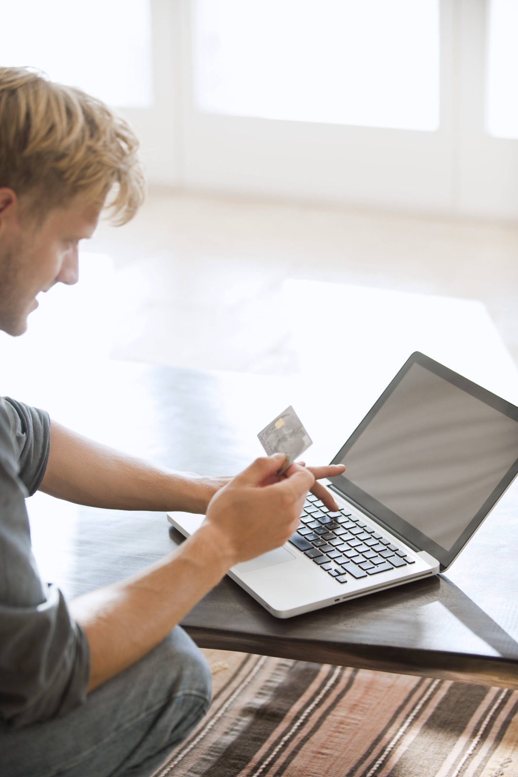 Mann mit MasterCard am Laptop