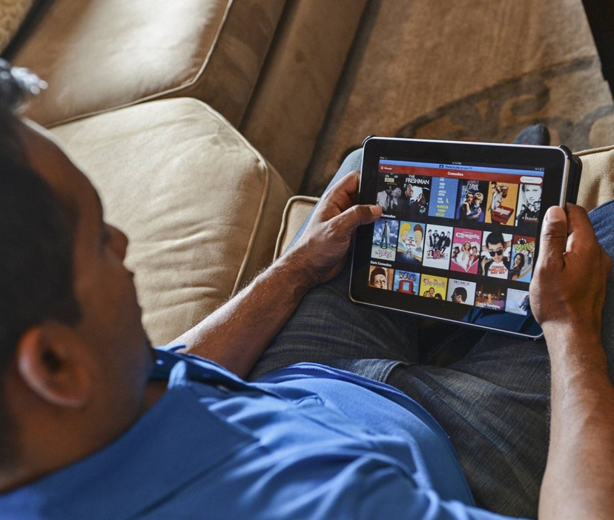 Mann mit Netflix auf dem Tablet auf dem Sofa