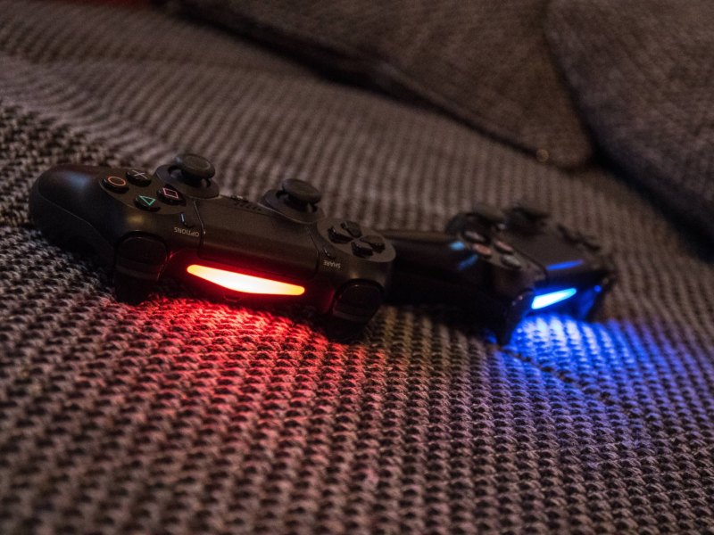 Zwei PlayStation 4 Controller auf dem Sofa.