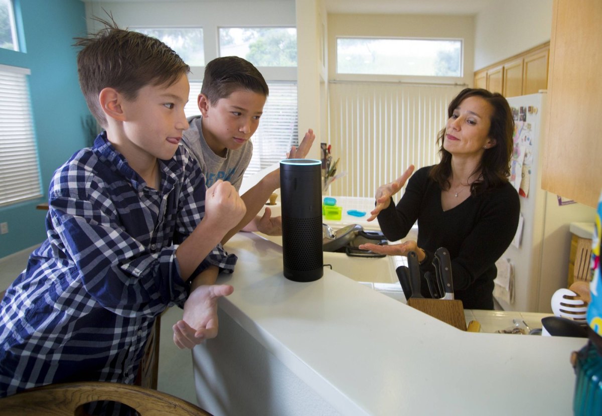 Eine Familie spricht mit einem Amazon-Lautsprecher.