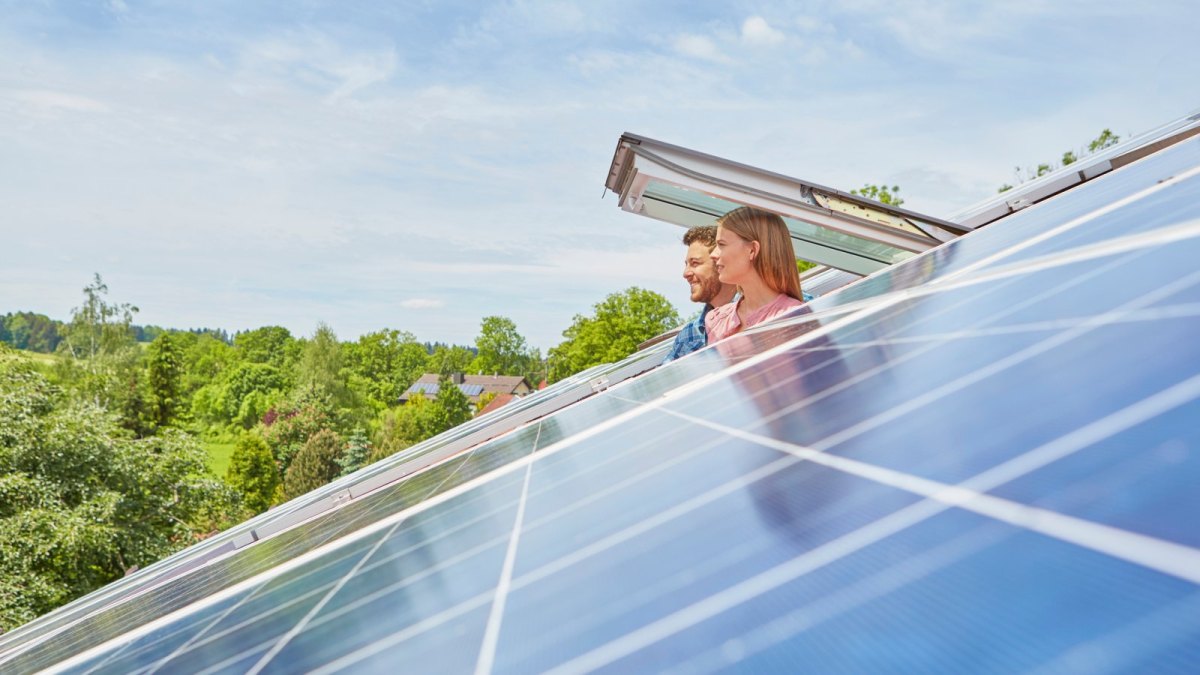 Paar schaut aus Dachfenster Solaranlagen