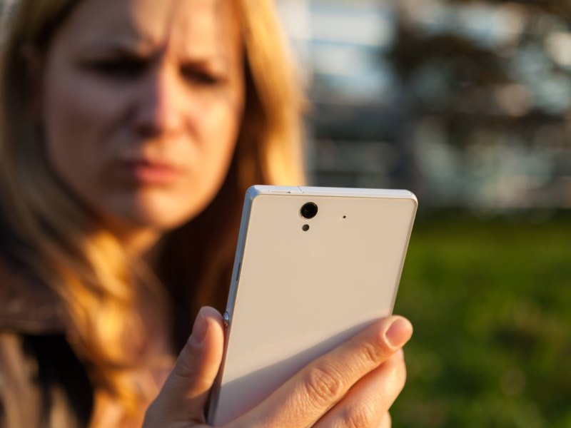 Frauk guckt sauer auf ihr Smartphone