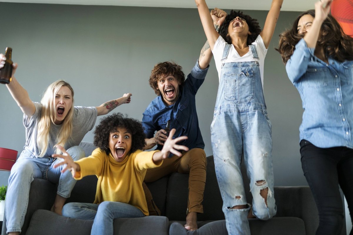 Gruppe von Freunden sitzt auf der Couch und brüllt.