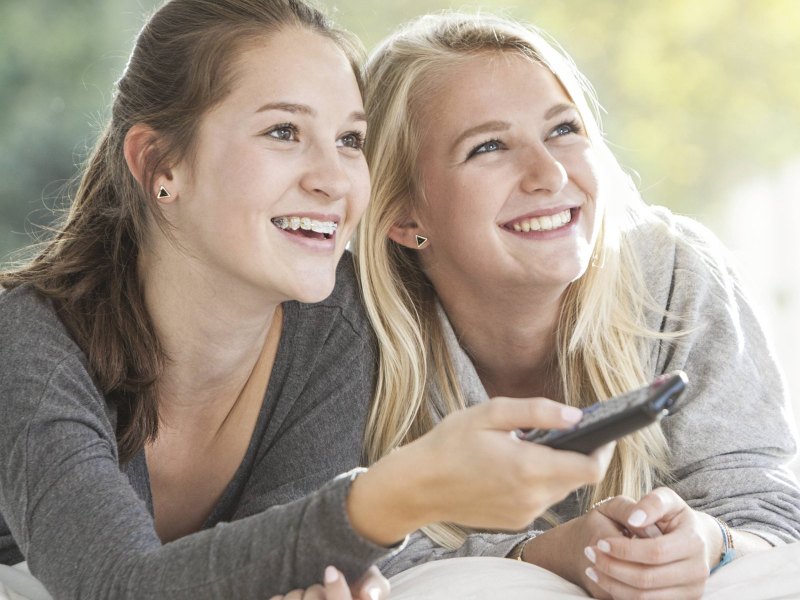 Zwei weibliche Teenager sehen fern.