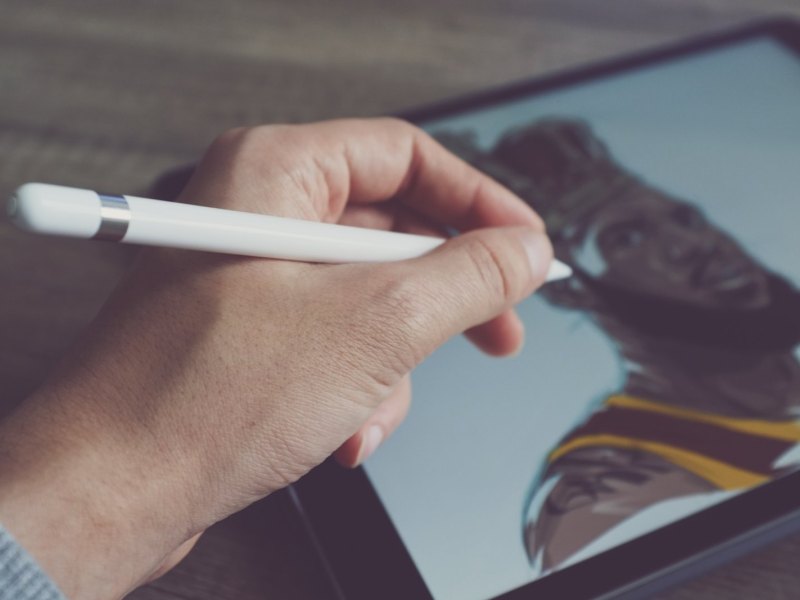 Person hält Apple Pencil ans Tablet