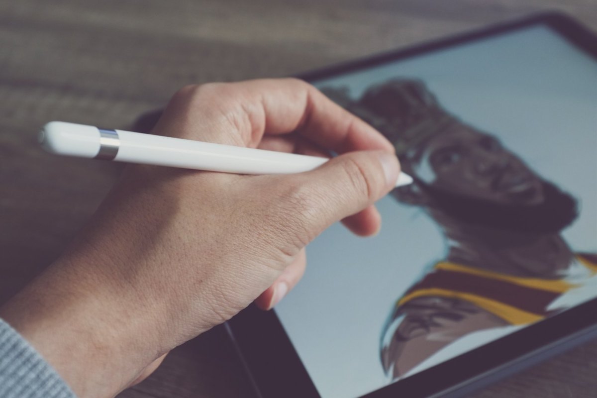 Person hält Apple Pencil ans Tablet