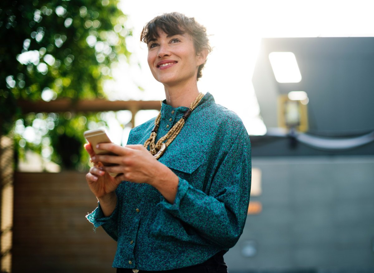 Glückliche Frau mit Handy in der Hand