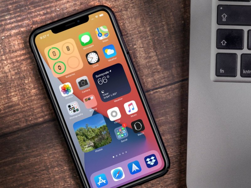 iPhone mit iOS 14 neben einem MacBook.