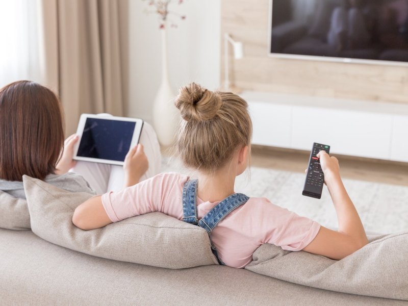 Mädchen mit iPad vor dem Fernseher