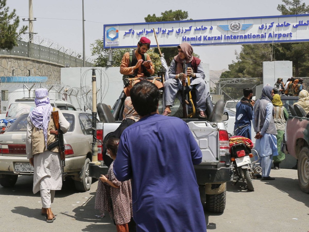 Männer mit Waffen sitzen auf einem Auto vor einem Flughafen in Kabul am 17. August 2021.