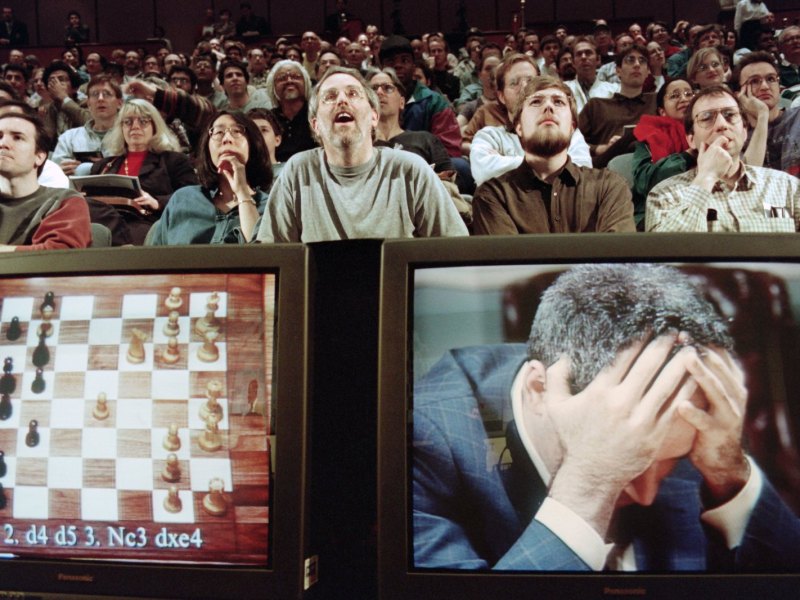 Zwei Montore zeigen ein Schachbrett (links) und Schachweltmeister Garry Kasparov (rechts)