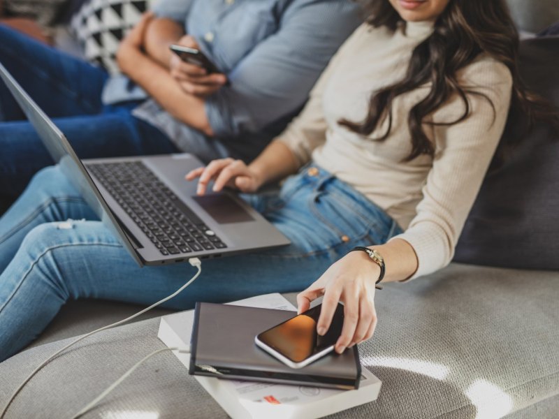 Frau mit Laptop und Powerbank.