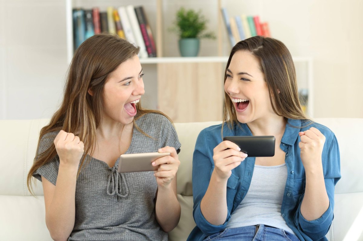 zwei frauen freuen sich über ihre handys