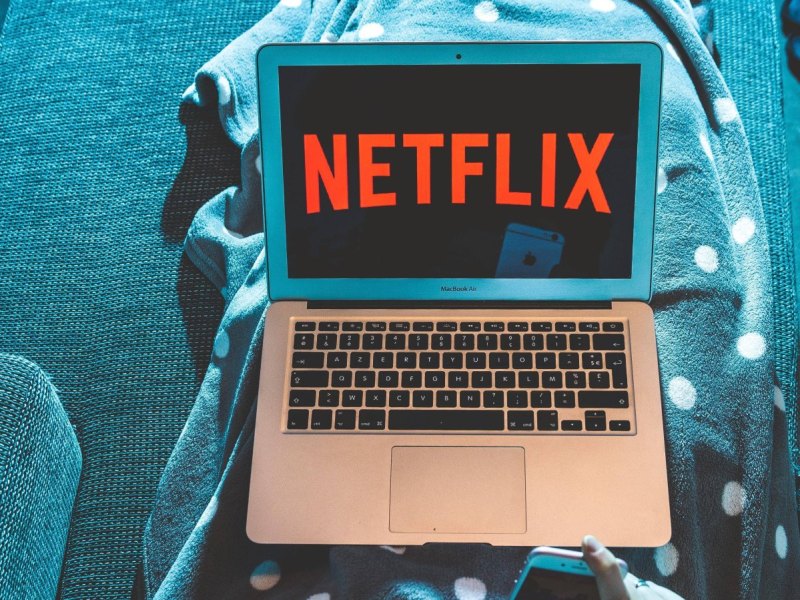 Laptop mit Netflix liegt auf Decke