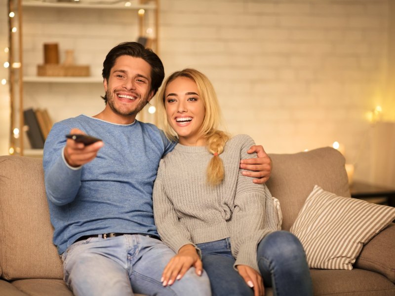 Ein Prächen sitzt vor dem Fernseher.