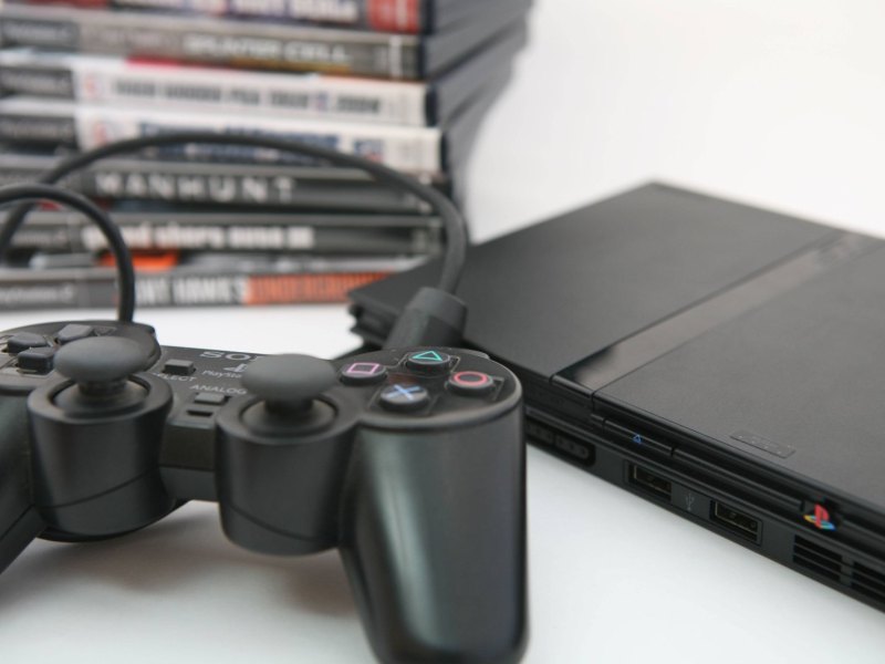 PS2-Controller mit Konsole und Spielen im Hintergrund