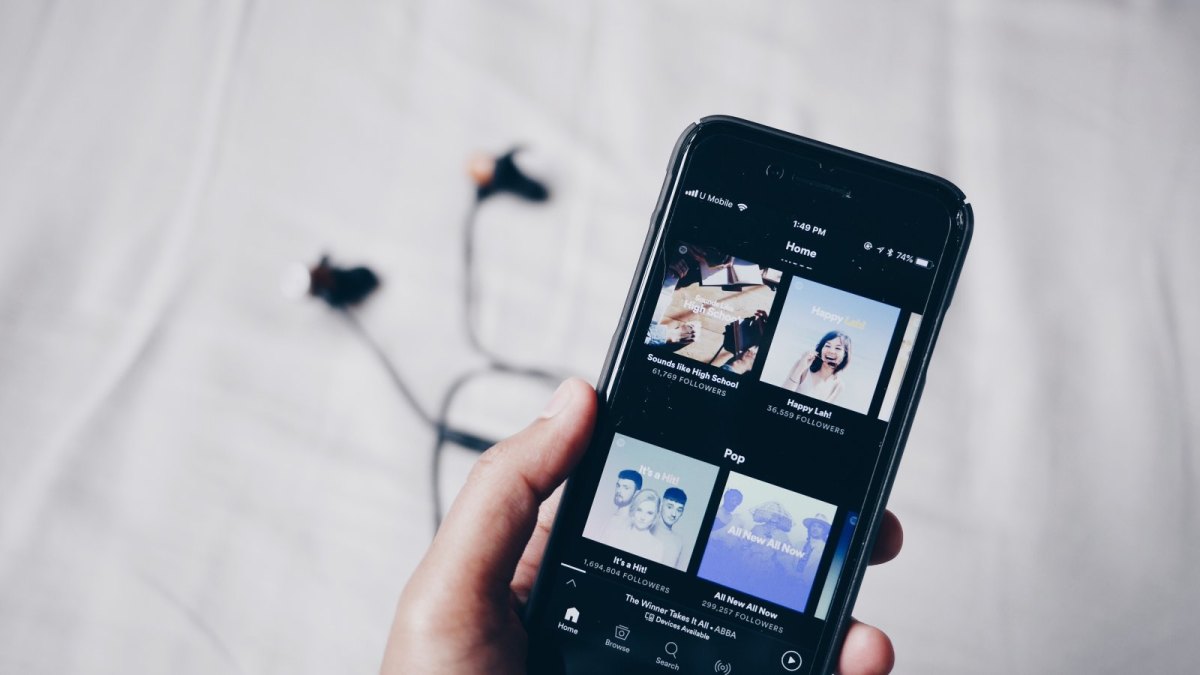 Person hält Smartphone mit Spotify