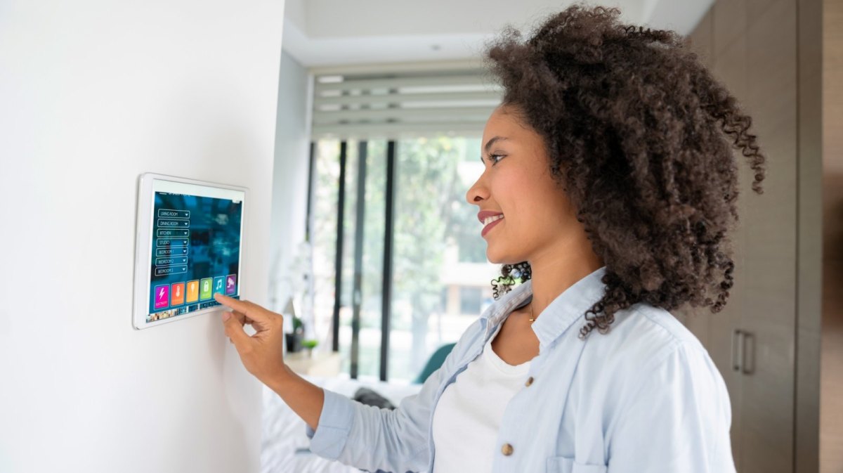 Frau mit Tablet an der Wand