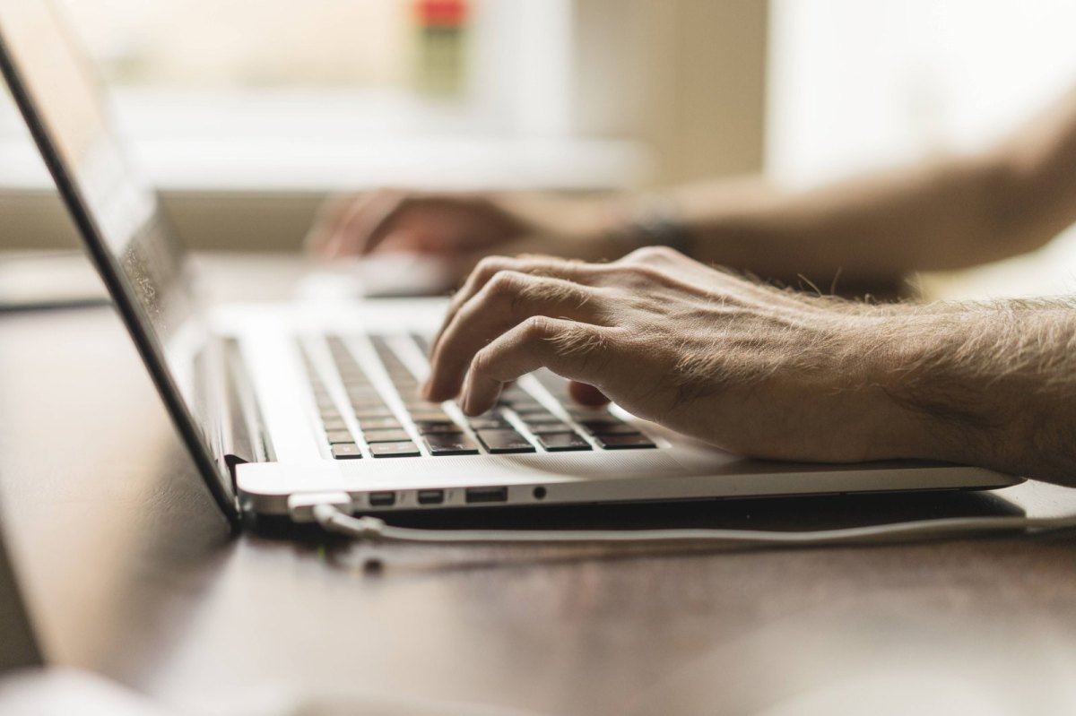 Person tippt auf Laptop-Keyboard