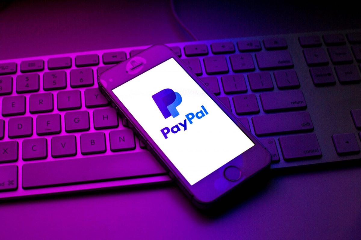 Handy mit PayPal-Logo auf Tastatur liegend