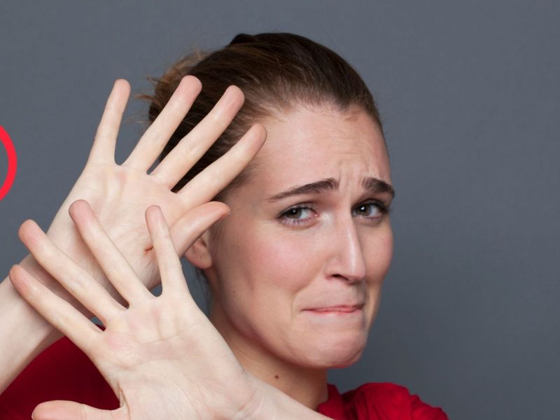 Frau hält sich ängstlich Hände vor das Gesicht.