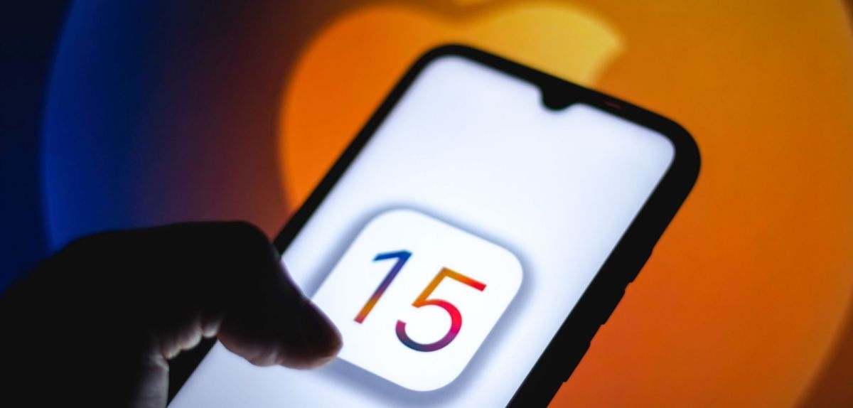 iPhone mit iOS 15 vor einem Apple-Logo