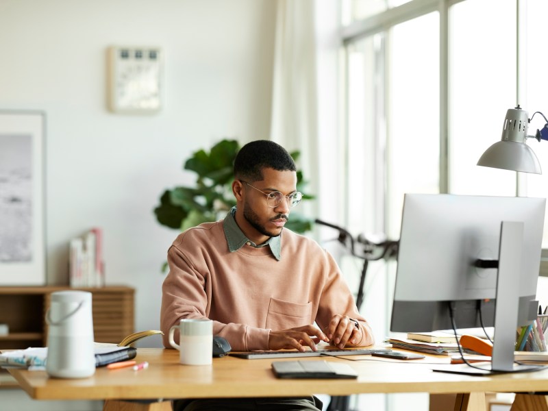 Mann sitzt am PC und arbeitet