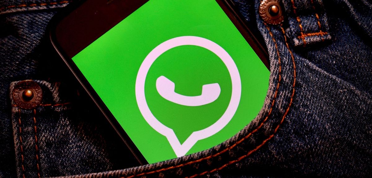 WhatsApp (Logo) auf einem Smartphone in einer Hosentasche