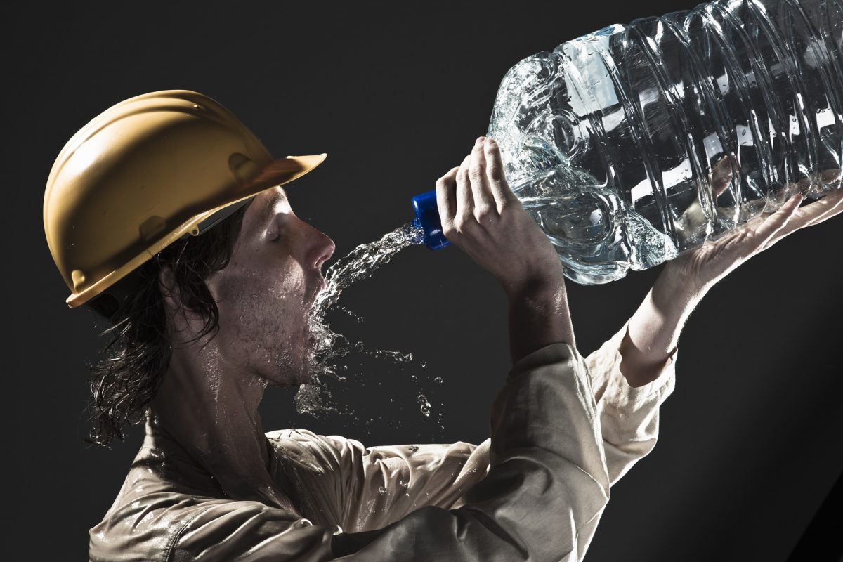 Mann trinkt Wasser aus einer groÃŸen Flasche