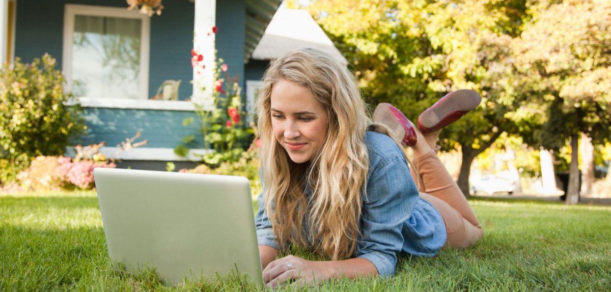 Frau mit Laptop im Garten