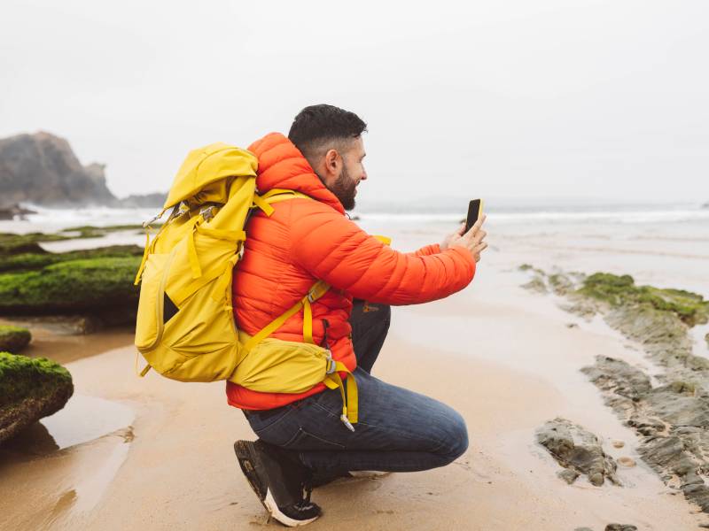 Outdoor-Handy wird von Mann zum Fotografieren an KÃ¼ste genutzt