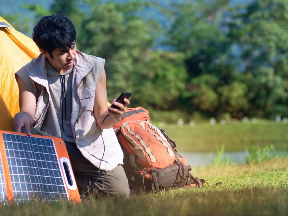 Mann mit Solar-LadegerÃ¤t am Handy