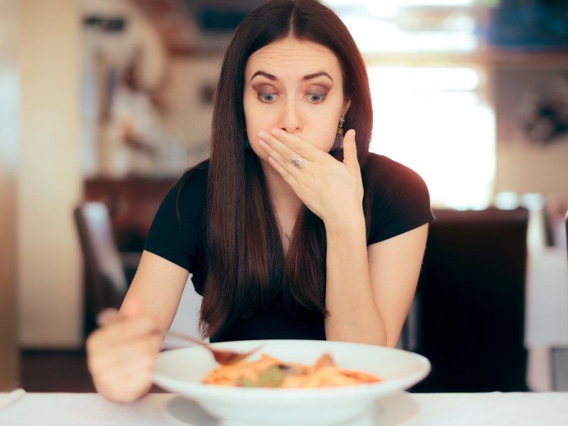 FRau isst Pasta und ihr wird übel