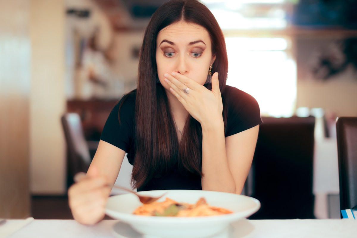 FRau isst Pasta und ihr wird übel