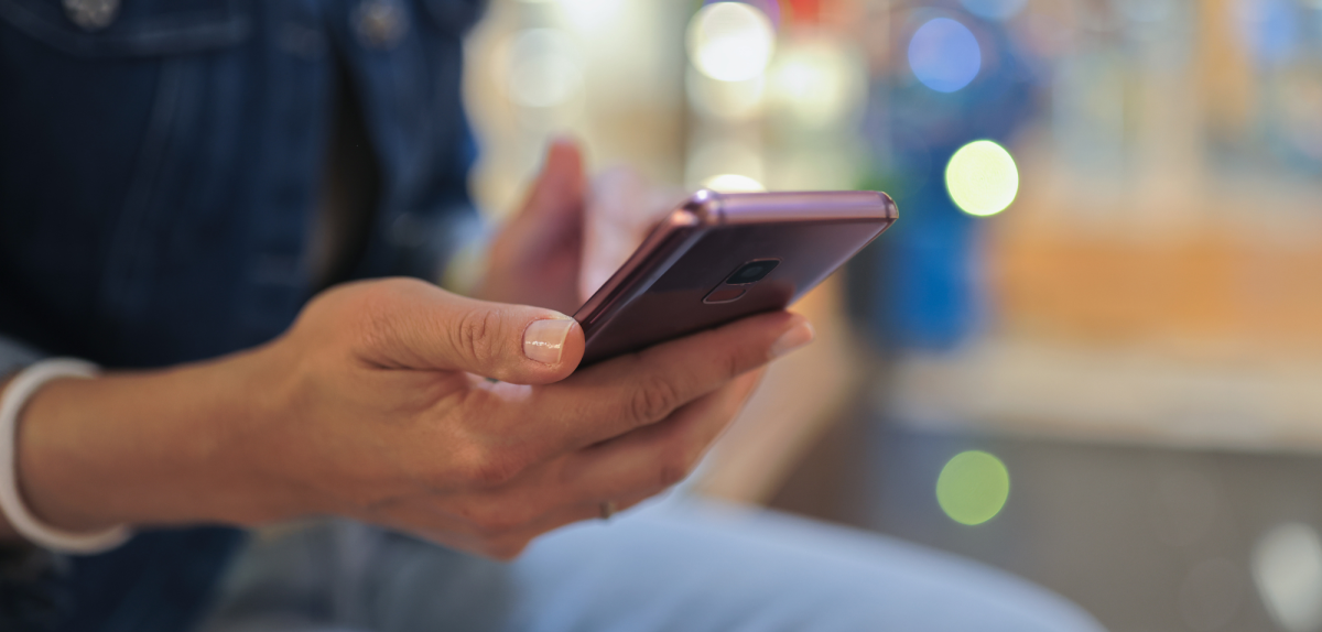 Person hält Smartphone in der Hand.