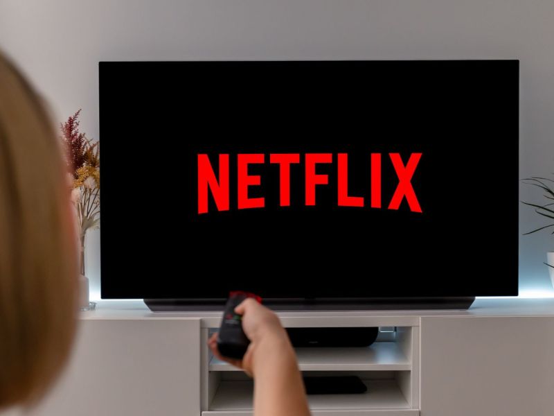 Frau sieht auf einem TV Netflix.