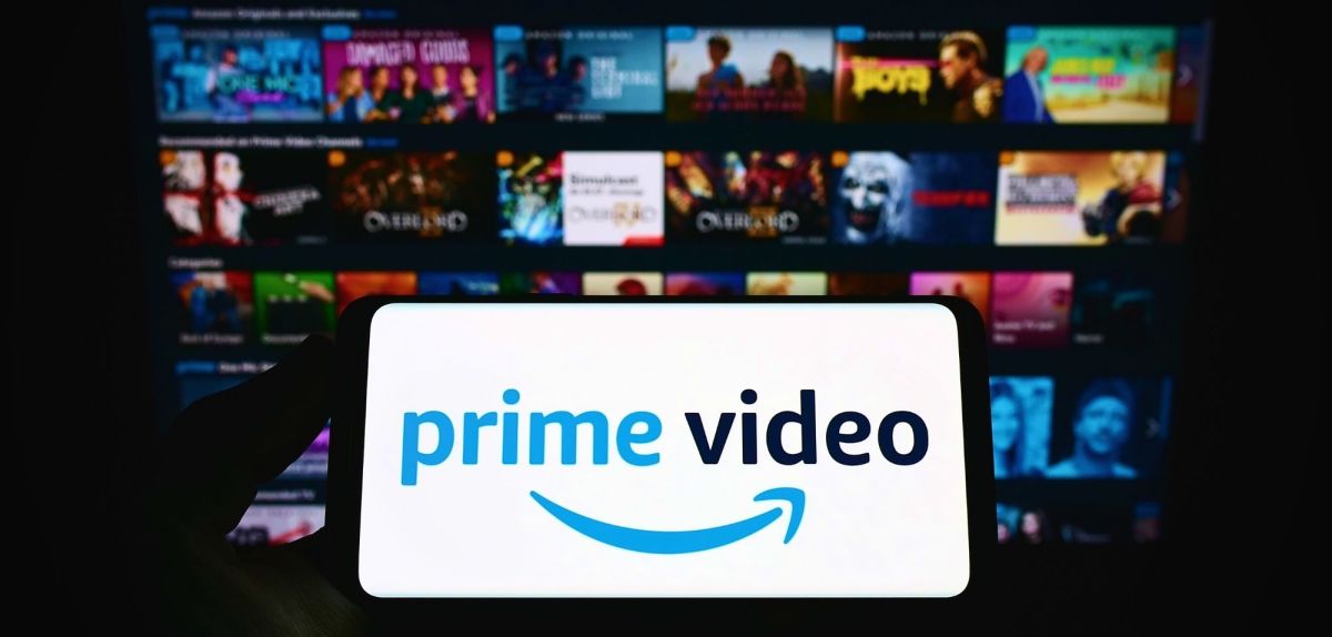 Handy-Display mit dem Logo von Amazon Prime Video, im Hintergrund zahlreiche Filmkacheln.